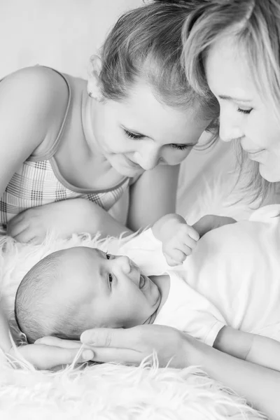幸福的母亲和女儿微笑着看着新生儿 — 图库照片