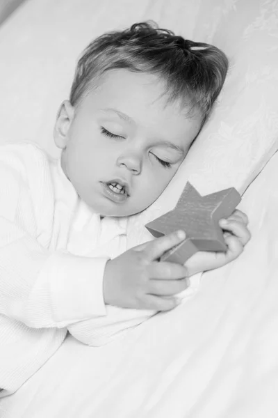 Niño pequeño durmiendo dulcemente con un juguete — Foto de Stock