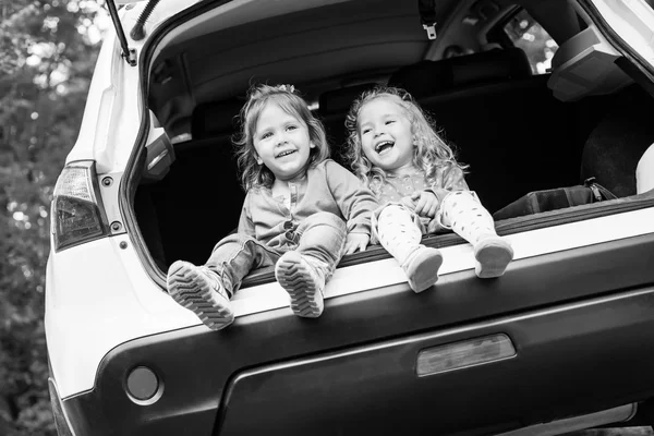 Riant filles tout-petits assis dans la voiture — Photo