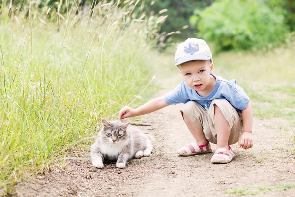 Bir kedi ile yürümeye başlayan çocuk — Stok fotoğraf