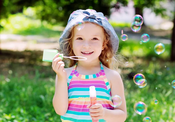 Bambino felice ragazza soffiando bolle di sapone — Foto Stock