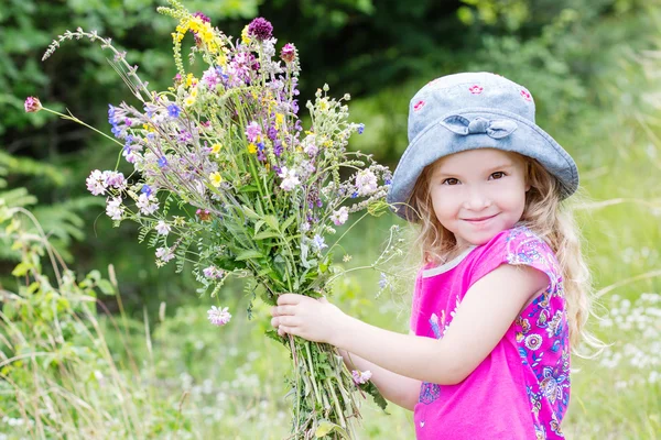 Happy toddler girl holding a bouquet — Stock Photo, Image