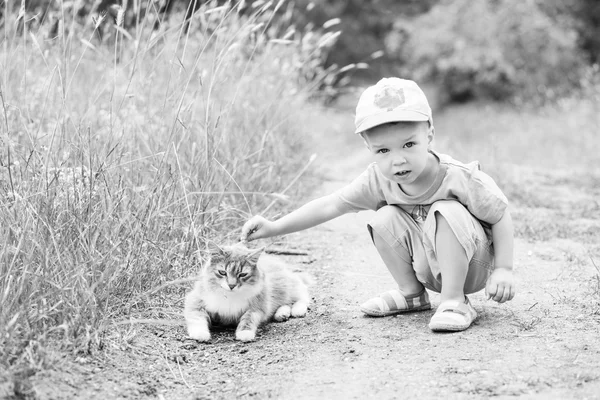 Bir kedi ile yürümeye başlayan çocuk — Stok fotoğraf