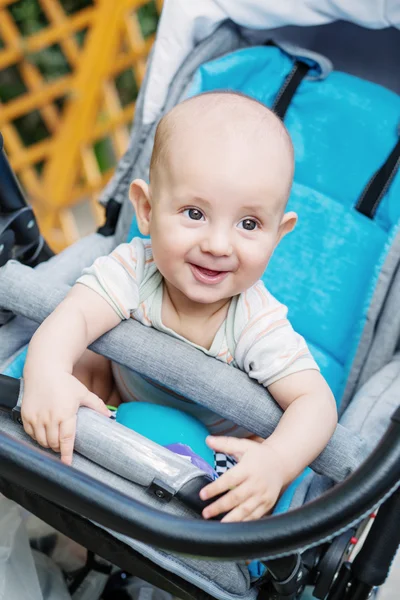 Gelukkig babyjongen zitten in een wandelwagen — Stockfoto