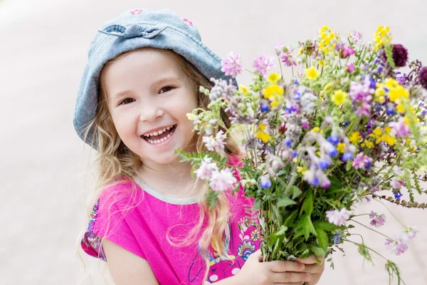 Happy toddler girl holding a bouquet — Stock Photo, Image