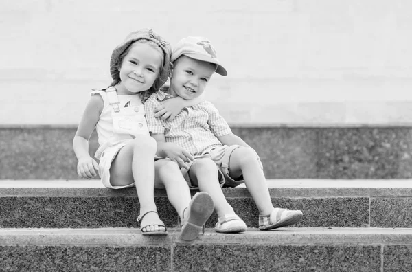 Niños felices se sientan en los escalones —  Fotos de Stock