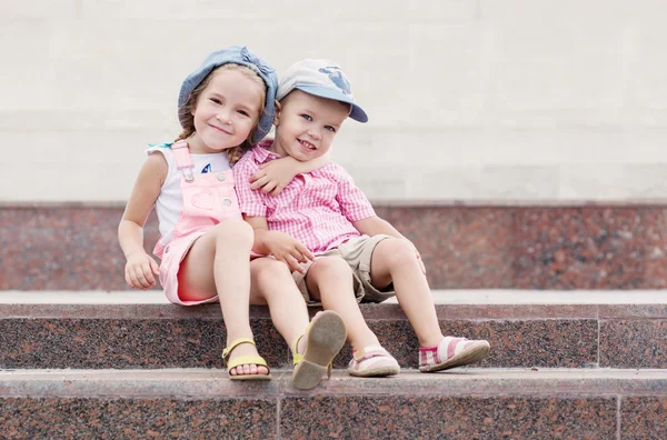 Niños felices se sientan en los escalones — Foto de Stock