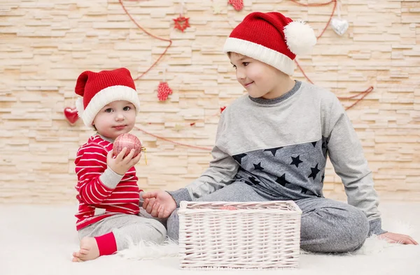 Two cute little brother in Santa hats — Stock Photo, Image