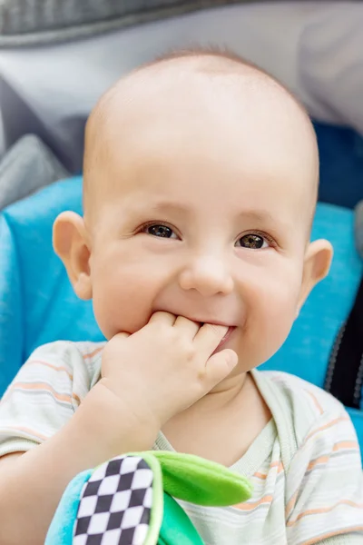 Happy baby boy sitting in a blue stroller — Stock Photo, Image