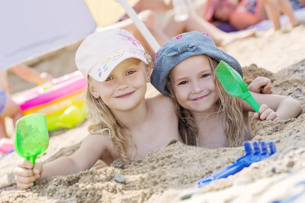 Two little girls playing in the sand — Stock Photo, Image