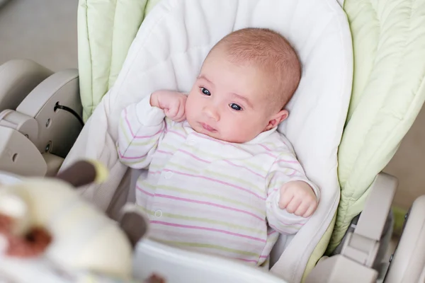 Portrait of a newborn girl in a highchair — Stock Photo, Image