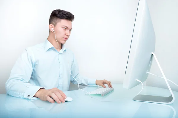 Un hombre de negocios trabajando en la computadora en la oficina en el escritorio — Foto de Stock