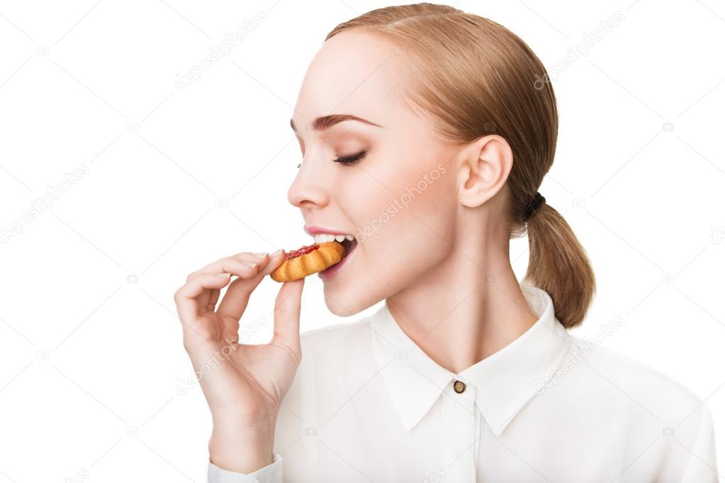 Profile of young beautiful healthy woman with cookie