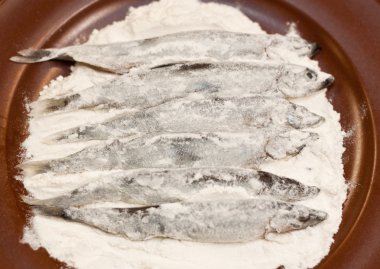capelin in flour before cooking clipart