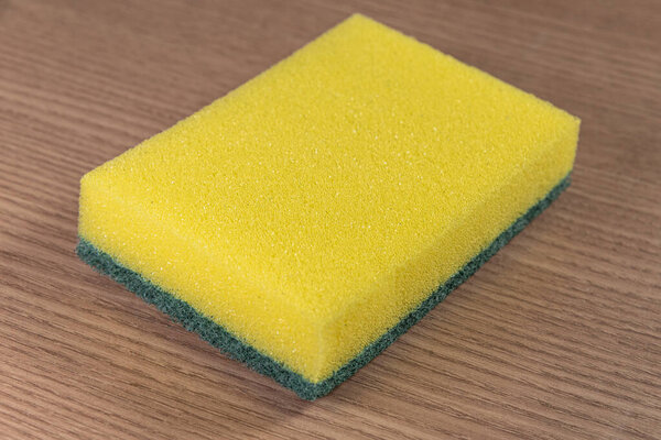Kitchen sponge on the wooden background