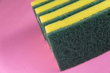 Pembe arka planda mutfak süngeri.