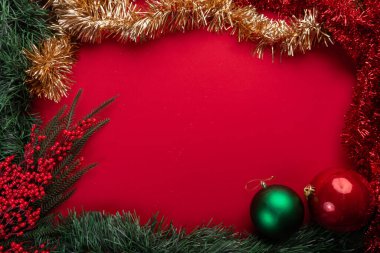 Canlı kırmızı arkaplanda şenlikli noel dekorasyonu