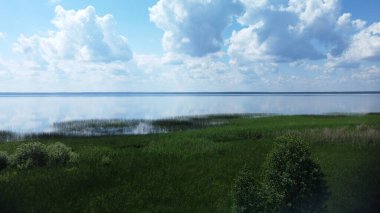 Sakin göl. Suya yansıyan bulutlu mavi gökyüzü. Su ve gökyüzü. 