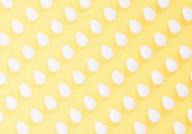 Açık sarı arkaplanda beyaz paskalya yumurtaları, yumurta desenleri, 3 boyutlu resimler.