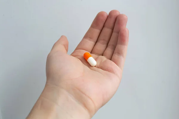 Большие белые и красные цвета капсулы таблетки на ладони, лечение бактериальной инфекции — стоковое фото