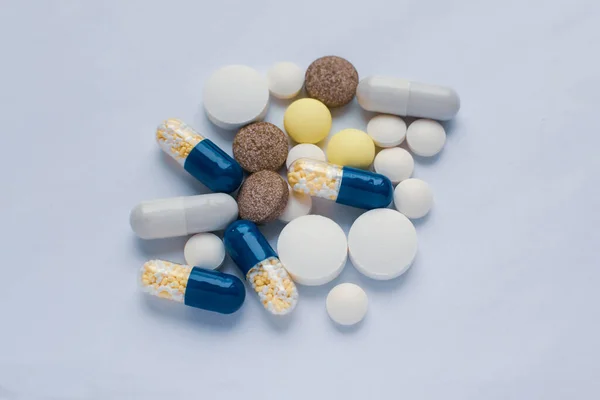 Tabletter och piller på det vita bordet, konsumerar en hel del piller koncept — Stockfoto