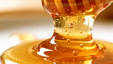 Tahta bir baldan damlayan altın balın yakın plan çekimi, doğal organik tatlılık konsepti, sağlıklı besin bileşeni, arıcılık ürünü, sağlık ve temiz beslenme geçmişi..