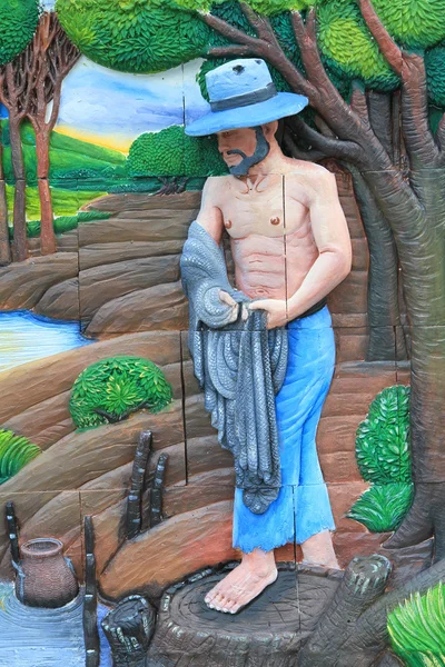 BANGKOK, TAILANDIA - 11 de junio: Tallado en piedra y pintura de pescador con red en la pared del templo en Wat Dan el 11 de junio de 2016 en Bangkok, Tailandia . — Foto de Stock