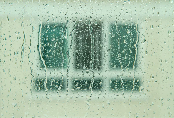 Regentropfen auf Spiegel mit verschwommenem Fenster im Hintergrund — Stockfoto