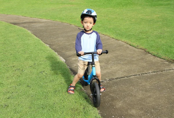 アジアの少年に乗って、彼の自転車を見て — ストック写真