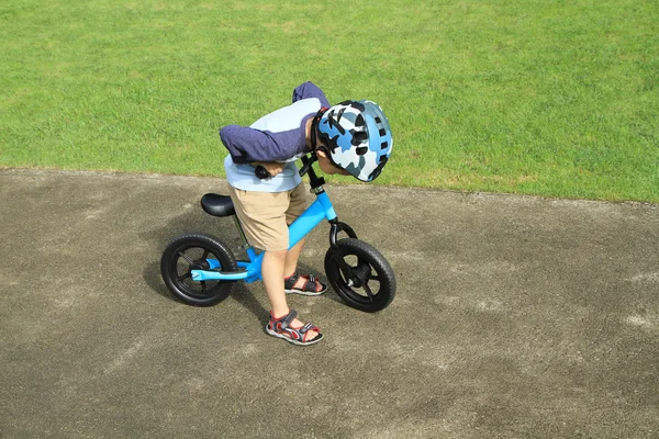 アジアの少年に乗って、彼の自転車を見て — ストック写真