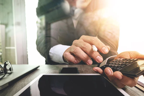 Geschäftsmann arbeitet mit Kalkulator und Smartphone und Laptop — Stockfoto