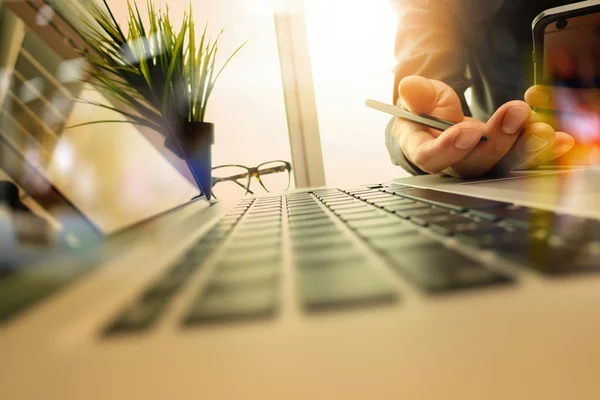 Designer mão de trabalho e telefone inteligente e laptop na mesa de madeira — Fotografia de Stock