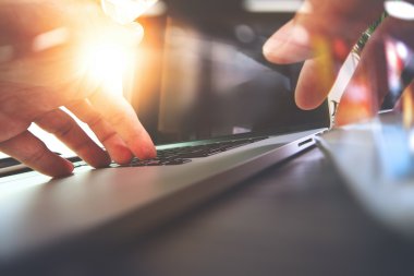Tasarımcı el ile dizüstü bilgisayar üzerinde ahşap çalışma yakın çekim