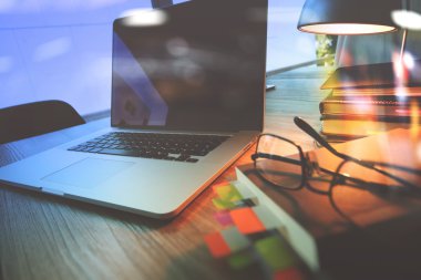 Bilgisayarı ve ahşap masasında akıllı telefonu olan bir ofis. 