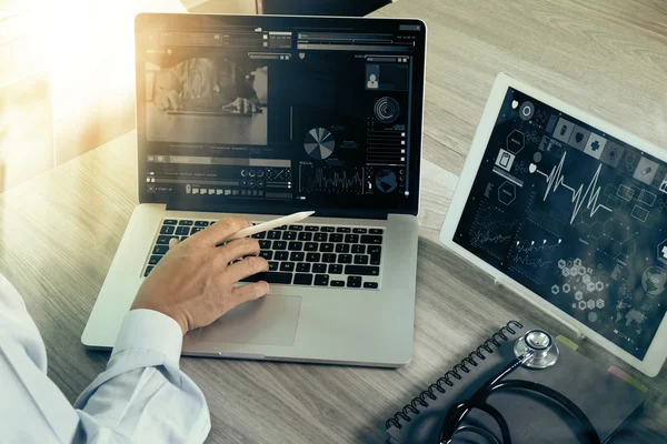 Médico trabalhando com laptop e tablet — Fotografia de Stock