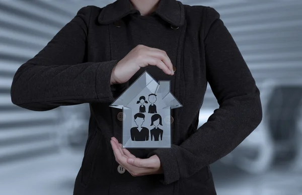 Affärsman handen håller 3d hus med familj ikonen som försäkring — Stockfoto