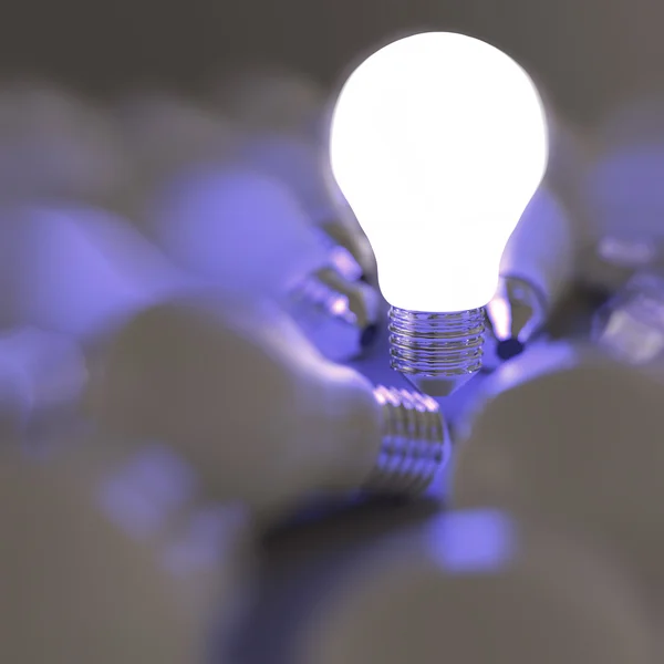 Growing light bulb standing out from the unlit incandescent bulb