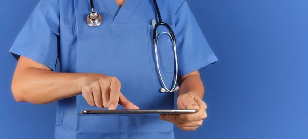 Doctor trabajando con tablet computeron fondo azul — Foto de Stock