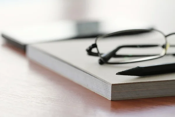 Închiderea notepad-ului gol cu creion pe masa de lemn de birou — Fotografie, imagine de stoc
