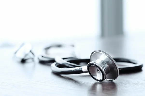 Stethoscope with digital tablet computer on wooden table and  ba — Stock Photo, Image