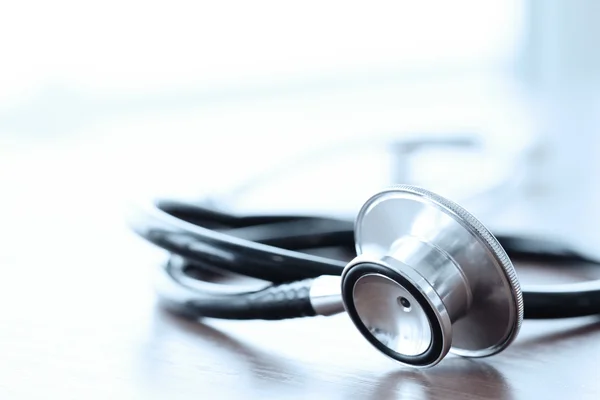 Stethoscope with digital tablet computer on wooden table and  ba — Stock Photo, Image