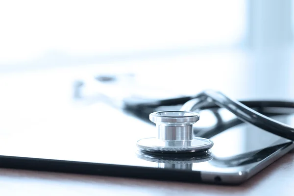 Stethoscope with digital tablet computer on wooden table and  ba — Stock Photo, Image