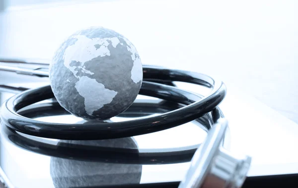 Studio macro of a stethoscope and texture globe with digital tab — Stock Photo, Image