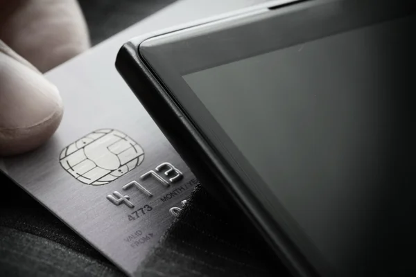 Kreditkort i mycket grunt fokus med grå kostym bakgrund — Stockfoto