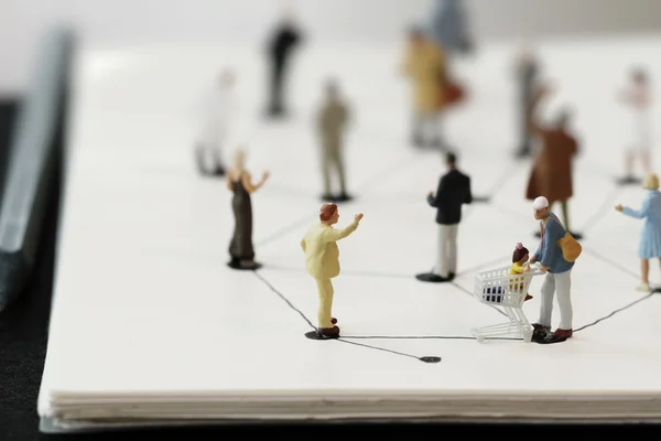 Close up of miniature people with social network diagram on open — Stock Photo, Image