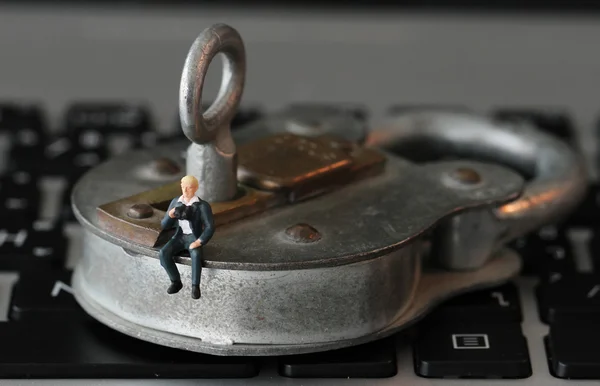 Internet beveiliging concept-miniatuur zakenman stand op oude sleutel — Stockfoto