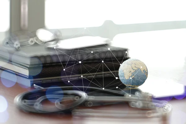 Студийный макрос стетоскопа и текстурного глобуса с цифровой вкладкой — стоковое фото
