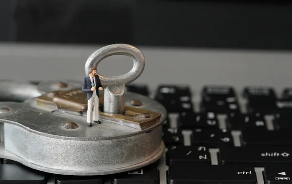Internet beveiliging concept-miniatuur zakenman stand op oude sleutel — Stockfoto