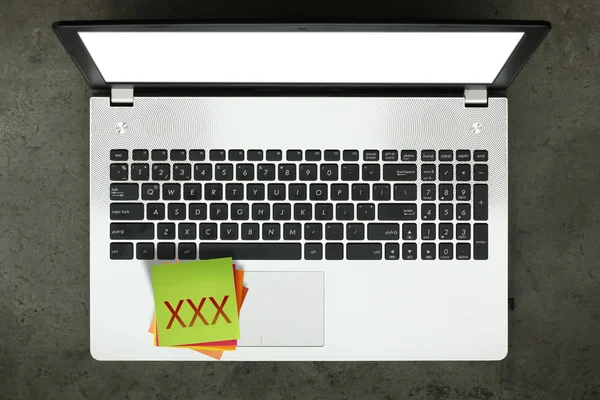 XXX op syicky opmerking met leeg scherm laptopcomputer op textuur — Stockfoto