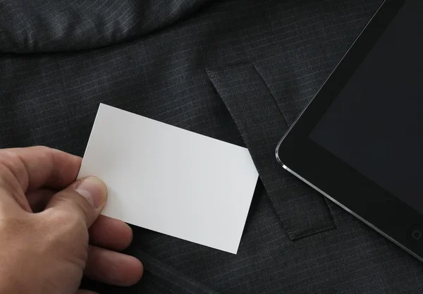 Primer plano de la mano recoger la tarjeta de visita en blanco de la paleta de traje gris — Foto de Stock